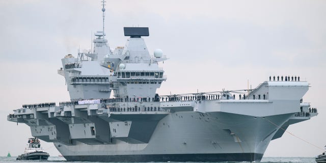 O super porta-aviões HMS Queen Elizabeth embarca no porto em 16 de agosto de 2017 em Portsmouth, Inglaterra.  O HMS Queen Elizabeth é o carro-chefe da nova classe de superportadores Queen Elizabeth.  Pesando 65.000 toneladas, é o maior navio de guerra implantado pela Marinha Real Britânica.  (Foto de Leon Neal / Getty Images)