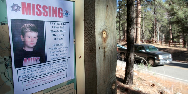 In this Nov. 26, 2012, file photo, a missing poster of 13-year-old Dylan Redwine hangs on a trail head sign next to Vallecito Reservoir in Vallecito, Colo.