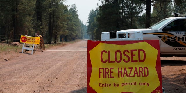 The Coconino County Sheriff's Office blocks off a U.S. Forest Service Road outside of Flagstaff, Ariz., on Monday, June 21, 2021. Dozens of wildfires were burning in hot, dry conditions across the U.S. West, including a blaze touched off by lightning that was moving toward northern Arizona's largest city. (Brady Wheeler/Arizona Daily Sun via AP)