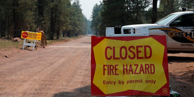 The Coconino County Sheriff's Office blocks off a U.S. Forest Service Road outside of Flagstaff, Ariz., on Monday, June 21, 2021. Dozens of wildfires were burning in hot, dry conditions across the U.S. West, including a blaze touched off by lightning that was moving toward northern Arizona's largest city. (Brady Wheeler/Arizona Daily Sun via AP)