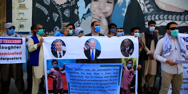 In this June 25, 2021 photo, Former Afghan interpreters hold placards during a demonstrations against the US government, in front of the US Embassy in Kabul, Afghanistan. 