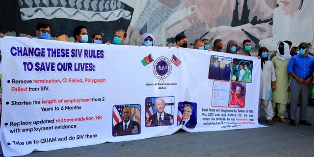 In this June 25, 2021 photo, former Afghan interpreters hold placards during a demonstrations against the US government, in front of the US Embassy in Kabul, Afghanistan. 