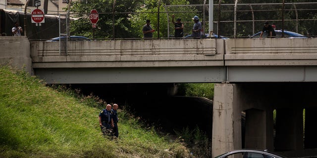 Michigan State Police examine a vehicles sitting in floodwaters on I-94 after a flood overwhelmed the interstate this past Friday June 25, 2021, the floodwaters have yet to subside on Monday, June 28 2021 in Detroit, Mich. (Nicole Hester/The Grand Rapids Press via AP)