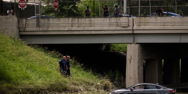 Michigan State Police examine a vehicles sitting in floodwaters on I-94 after a flood overwhelmed the interstate this past Friday June 25, 2021, the floodwaters have yet to subside on Monday, June 28 2021 in Detroit, Mich. (Nicole Hester/The Grand Rapids Press via AP)