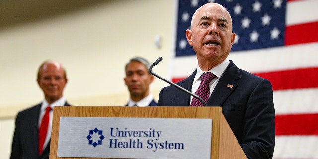 Homeland Security Secretary Alejandro N. Mayorkas speaks at the Wonderland of the Americas COVID-19 vaccination hub on Tuesday, June 29, 2021, to reiterate the importance of getting people vaccinated against COVID-19, and to highlight cooperation between agencies to eradicate the coronavirus. Bexar County Judge Nelson Wolff, left, and Mayor Ron Nirenberg, middle, listen. (Billy Calzada/The San Antonio Express-News via AP)