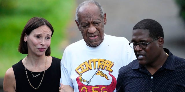 Comedian Bill Cosby, center, and spokesperson Andrew Wyatt, right, approach members of the media gathered outside Cosby's home in Elkins Park, Pa., Wednesday, June 30, 2021, after Pennsylvania's highest court overturned his sex assault conviction.