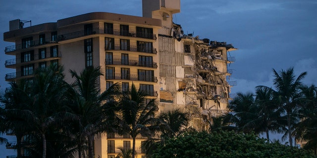 FILE - In this June 30, 2021, file photo, light shines on the Champlain Towers South as search and rescue teams continue looking for survivors of the partially collapsed residential building in Surfside, Fla. Dozens of people escaped with their lives, but little else. The disaster that killed at least 18 people, with more than 140 still missing, has also left many survivors homeless. (Pedro Portal/Miami Herald via AP, File)