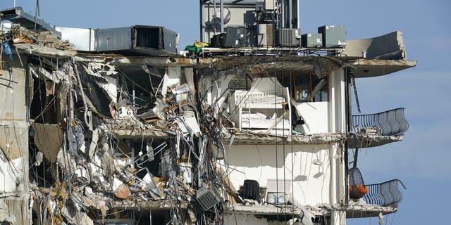 Furniture sits perched in the remains of apartments sheared in half, in the still standing portion of the Champlain Towers South condo building, more than a week after it partially collapsed, 星期五, 七月 2, 2021, in Surfside, 弗拉. (美联社照片/马克·汉弗莱)