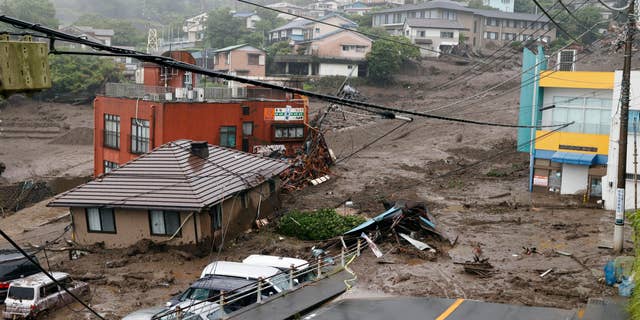 This photo shows buildings damaged by a mudslide at the Izusan district in Atami, west of Tokyo, Saturday, July 3, 2021, following heavy rains in the area. The mudslide carrying a deluge of black water and debris crashed into rows of houses in the town following heavy rains on Saturday, leaving multiple people missing, officials said. (Kyodo News via AP)