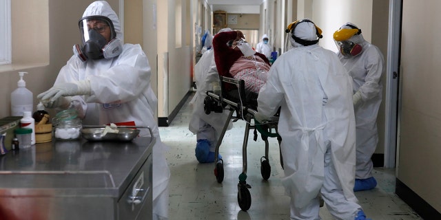 FILE - In this June 25, 2021, file photo, medical staff transport a COVID-19 patient at the Honorio Delgado Hospital in Arequipa, Peru. The global death toll from COVID-19 has eclipsed 4 million as the crisis increasingly becomes a race between the vaccine and the highly contagious delta variant. (AP Photo/Guadalupe Pardo, File)