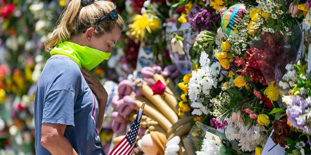 Miami Beach resident Tracy Lane visited a temporary memorial near the site of the collapsed Champlain Towers South Condo on Saturday, July 3, 2021 in Surfside, Florida. (Associated Press)