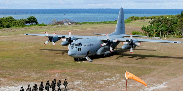 FILE - This April 21, 2017, file photo shows a Philippine Air Force C-130 transport plane as Philippine troops march at the Philippine-claimed Thitu Isloff the disputed Spratlys chain of islands in the South China Sea in western Philippines. The Philippine military chief said Sunday, July 4, 2021, a C-130 plane carrying troops has crashed in the country’s south after missing the runway multiple people have been rescued. (AP Photo/Bullit Marquez, File)