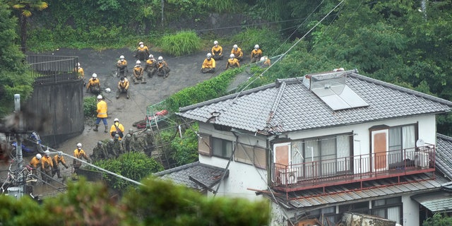 Houses are damaged by a mudslide following heavy rains at the Izusan district in Atami, Shizuoka prefecture, west of Tokyo, Sunday, July 4, 2021. The mudslide carrying a deluge of black water and debris crashed into rows of houses in the town following heavy rains on Saturday, leaving multiple people missing, officials said. (AP Photo/Eugene Hoshiko)