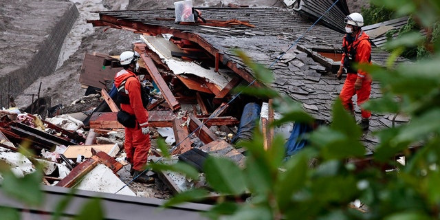 Rescuers conduct a search operation at the site of a mudslide at Izusan in Atami, Shizuoka prefecture, southwest of Tokyo, Sunday, July 4, 2021. More than 1,000 soldiers, firefighters and police on Sunday waded through a giant mudslide that ripped through the resort town as it swept away houses and cars. (Kyodo News via AP)