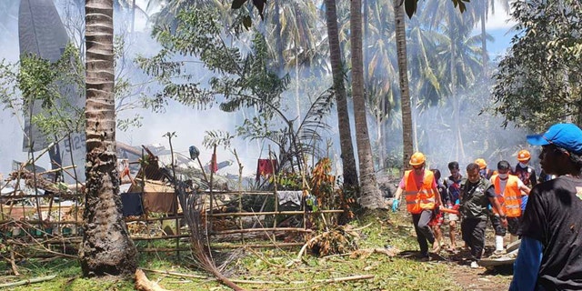 THIS CORRECTS THE NAME OF THE PROVINCE TO SULU, INSTEAD OF JOLO - In this photo released by the Joint Task Force - Sulu, rescuers carry a body from the site where a Philippine military C-130 plane crashed in Patikul town, Sulu province, southern Philippines on Sunday, July 4, 2021. The Philippine air force C-130 aircraft carrying troops crashed in a southern province after missing the runway Sunday, killing more than a dozen military personnel while at least 40 were rescued from the burning wreckage, officials said. (Joint Task Force-Sulu via AP)