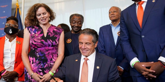 Surrounded by supporters and advocates, New York Governor Andrew Cuomo, center, signs legislation on gun control in New York, Tuesday, July 6, 2021. Cuomo signed two pieces of legislation to combat gun violence in New York state.