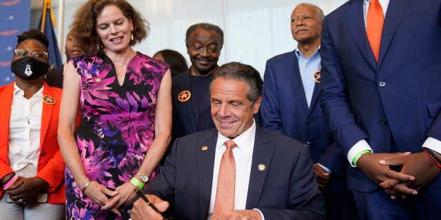 Surrounded by supporters and advocates, New York Governor Andrew Cuomo, center, signs legislation on gun control in New York, Tuesday, July 6, 2021. Cuomo signed two pieces of legislation to combat gun violence in New York state.