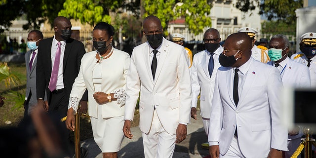 FILE - In this May 18, 2021 file photo, Haitian President Jovenel Moise, center, walks with first lady Martine Moise, left, and interim Prime Minister Claude Joseph, right, during a ceremony marking the 218th anniversary of the creation of the Haitian flag in Port-au-Prince, Haiti. Moïse was assassinated in an attack on his private residence early Wednesday, and the first lady was shot in the overnight attack and hospitalized, according to a statement from Joseph. (AP Photo/Joseph Odelyn, File)