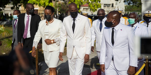 In this May 18, 2021 file photo, Haitian President Jovenel Moise, center, walks with first lady Martine Moise, left, and interim Prime Minister Claude Joseph, right, during a ceremony marking the 218th anniversary of the creation of the Haitian flag in Port-au-Prince, Haiti. (AP Photo/Joseph Odelyn, File)