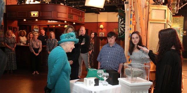 Britain's Queen Elizabeth II meets actors and members of the production team during a visit to the set of the long running television series Coronation Street, in Manchester, England, Thursday July 8, 2021.