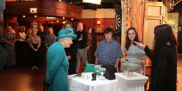 Britain's Queen Elizabeth II meets actors and members of the production team during a visit to the set of the long running television series Coronation Street, in Manchester, England, Thursday July 8, 2021.