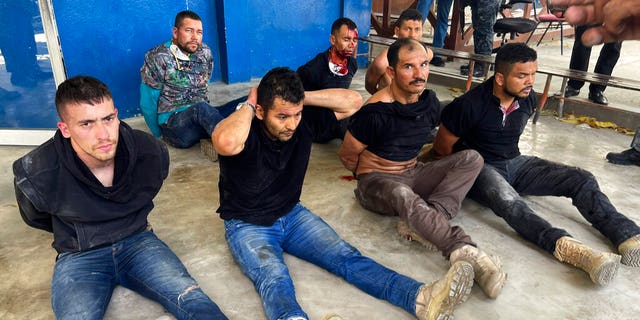 Suspects in the assassination of Haiti's President Jovenel Moise sit on the floor handcuffed after being detained, at the General Direction of the police in Port-au-Prince, Haiti, jueves, mes de julio 8, 2021. 