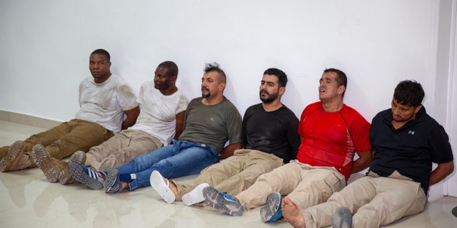 Suspects in the assassination of Haiti's President Jovenel Moise, among them Haitian-American citizens James Solages, left, and Joseph Vincent, second left, are shown to the media at the General Direction of the police in Port-au-Prince, Haiti, Thursday, July 8, 2021. Moise was assassinated in an attack on his private residence early Wednesday. (AP Photo/Joseph Odelyn)