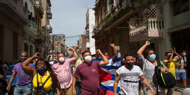 Government supporters shout slogans as anti-government protesters march in Havana, Cuba, Sunday, July 11, 2021. 