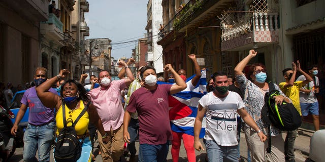 Government supporters shout slogans as anti-government protesters march in Havana, Cuba, Sunday, July 11, 2021.