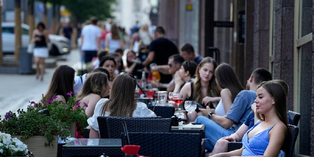 Menschen entspannen sich nach einem heißen Tag auf der Außenterrasse eines Restaurants in Moskau, Russland, Mittwoch, 14. Juli 2021 (dpa)