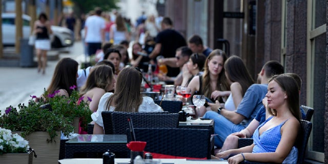 People relax after a hot day at an outdoor terrace of a restaurant in Moscow, Russia, Wednesday, July 14, 2021. (AP)