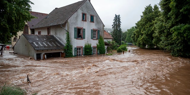 Houses are submerged on the overflowed river banks in Erdorf, Germany, as the village was flooded Thursday, July 15, 2021. Continuous rainfall has flooded numerous villages and cellars in Rhineland-Palatinate, southwestern Germany. (Harald Tittel/dpa via AP)