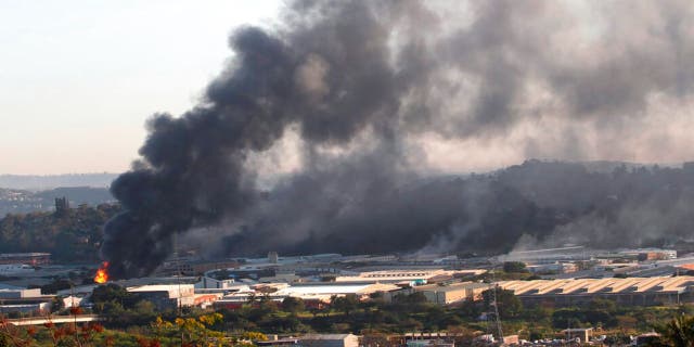 A building burns near Durban South Africa, Thursday, July 15, 2021, as unrest continues in the KwaZulu Natal province.