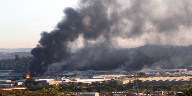 A building burns near Durban South Africa, Thursday, July 15, 2021, as unrest continues in the KwaZulu Natal province. 