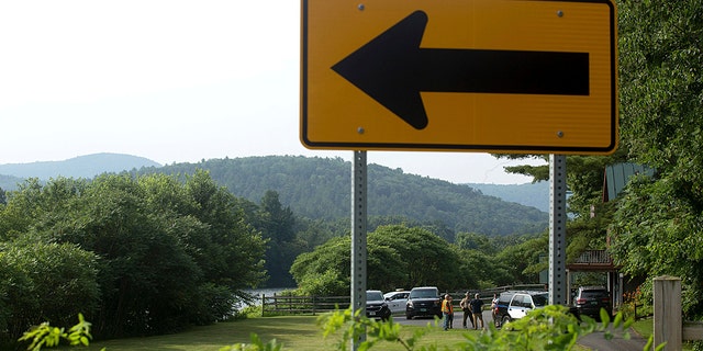 Investigators, including those from the Federal Aviation Administration, gather along the Connecticut River and Highway 25 in Bradford, Vermont on Friday, July 16, 2021, following the death of an aeronaut.  (Associated press)