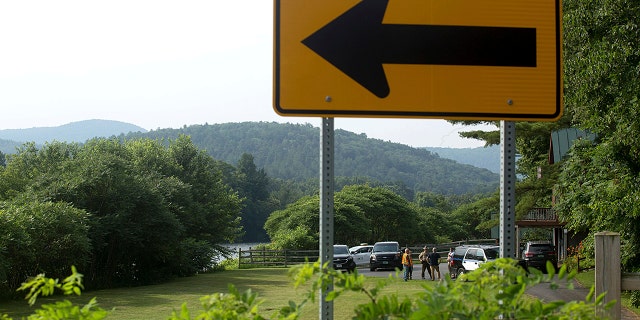 Investigators, including those from the Federal Aviation Administration, gather along the Connecticut River and Route 25 in Bradford, Vt., on Friday, July 16, 2021, following the death of a hot-air balloonist. (Associated Press)