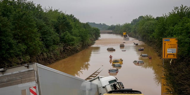 Cars show up as the flood sinks on a road in Erftstadt, Germany, Saturday, July 17, 2021. Due to strong rain falls the small Erft river went over the banks causing massive damages. (AP Photo/Michael Probst)