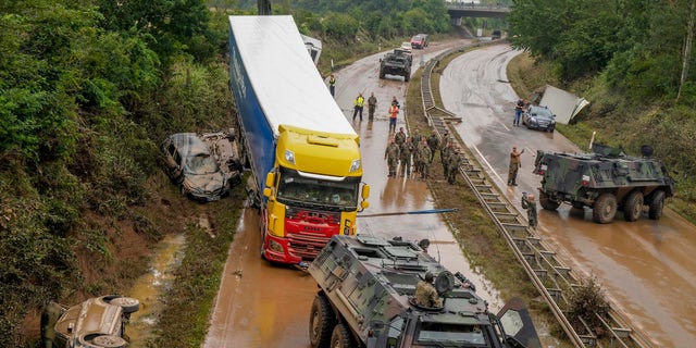 German army soldiers work on flooded cars and a truck on a road in Erftstadt, Germany, Saturday, July 17, 2021. Due to strong rain falls the small Erft river went over the banks causing massive damages. (AP Photo/Michael Probst)