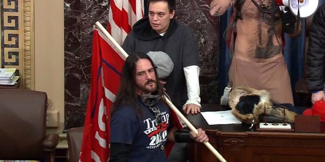 FILE - In this file image from U.S. Capitol Police video, Paul Allard Hodgkins, 38, of Tampa, Fla., front, stands in the well on the floor of the U.S. Senate on Jan. 6, 2021, at the Capitol in Washington. (U.S. Capitol Police via AP, File)