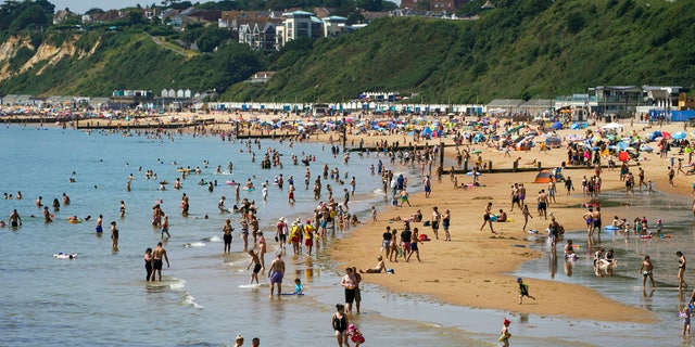 People enjoy the weather on Bournemouth beach in Dorset, England, Monday July 19, 2021. (Steve Parsons/PA via AP)