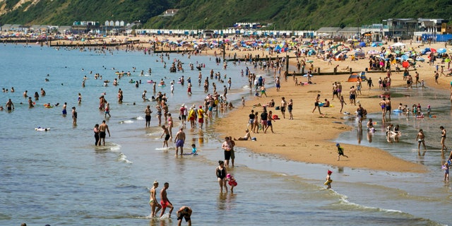 People enjoy the weather on Bournemouth beach in Dorset, England, Monday July 19, 2021. (Steve Parsons/PA via AP)