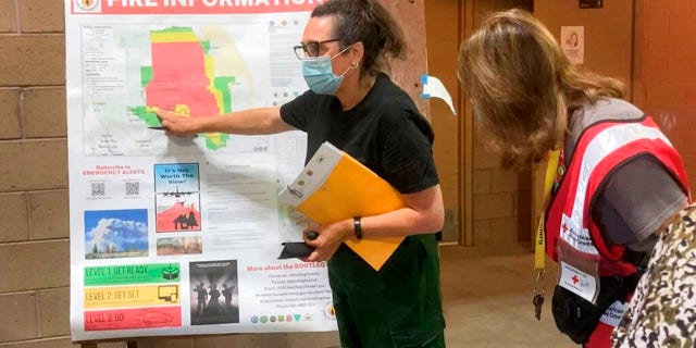 In this photo provided by the Bootleg Fire Incident Command, a public information officer talks with evacuees at a Red Cross Shelter near the Bootleg Fire in southern Oregon, Sunday, July 18, 2021. (Bootleg Fire Incident Command via AP)