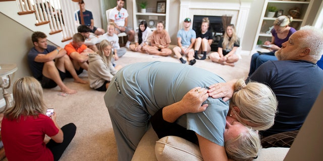 Amy Satterthwaite, the mother of Richie Mays Jr., gets a hug as family and friends gather to remember Kole Sova, Dawson Brown and Mays at the home of Jerry and Meeka Sova near Jackson, Mich., Sunday, July 18, 2021. (J. Scott Park/MLive.com/Jackson Citizen Patriot via AP)