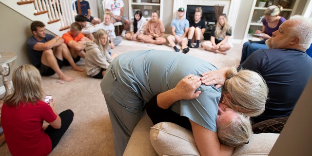 Amy Satterthwaite, the mother of Richie Mays Jr., gets a hug as family and friends gather to remember Kole Sova, Dawson Brown and Mays at the home of Jerry and Meeka Sova near Jackson, Mich., Sunday, July 18, 2021. (J. Scott Park/MLive.com/Jackson Citizen Patriot via AP)