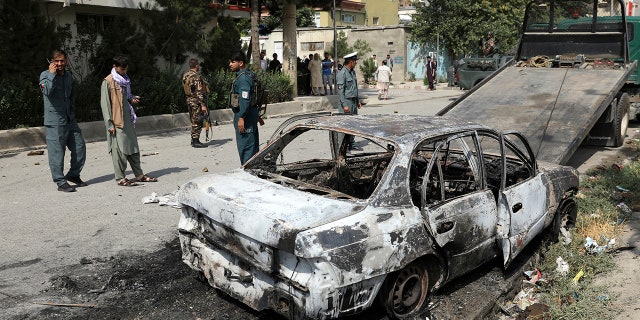 Security personnel inspect a damaged vehicle from which rockets were fired in Kabul, Afghanistan on Tuesday, July 20, 2021. (AP Photo / Rahmat Gul)