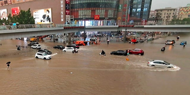Vehicles are stranded after a heavy downpour in Zhengzhou city, central China's Henan province on Tuesday, July 20, 2021. Heavy flooding has hit central China following unusually heavy rains, with the subway system in the city of Zhengzhou inundated with rushing water. (Chinatopix Via AP)