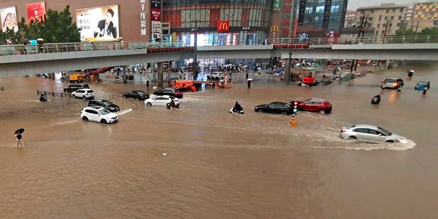 Vehicles are stranded after a heavy downpour in Zhengzhou city, central China's Henan province on Tuesday, July 20, 2021. Heavy flooding has hit central China following unusually heavy rains, with the subway system in the city of Zhengzhou inundated with rushing water. (Chinatopix Via AP)