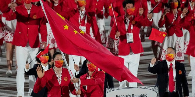 Zhu Ting and Zhao Shuai, of China, carry their country's flag during the opening ceremony in the Olympic Stadium at the 2020 Summer Olympics, Friday, July 23, 2021, in Tokyo, Japan. (AP Photo/David J. Phillip)