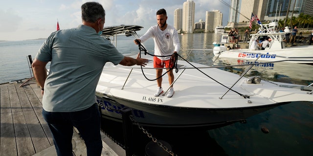 Ramon Saul Sanchez, left, leader of the nonprofit Movimiento Democracia which has launched several flotillas in the past, helps boater Julio Gonzalez moor his boat, Friday, July 23, 2021, in downtown Miami. (Associated press)