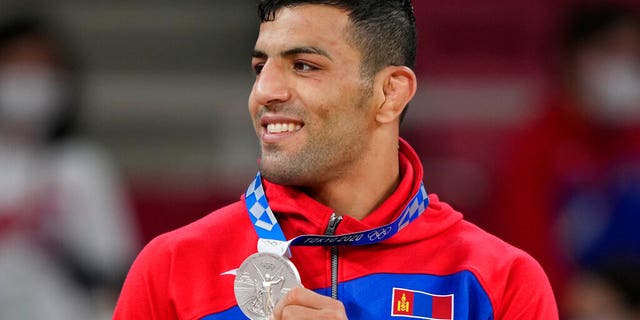 Saeid Mollaei of Mongolia celebrates with his silver medal during the award ceremony for the men -81kg judo match at the 2020 Summer Olympics in Tokyo, Japan, Tuesday, July 27, 2021. (AP Photo/Vincent Thian)